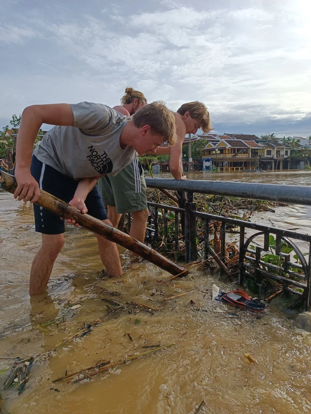 Du khách nước ngoài giúp sức dọn rác sau bão Noru
